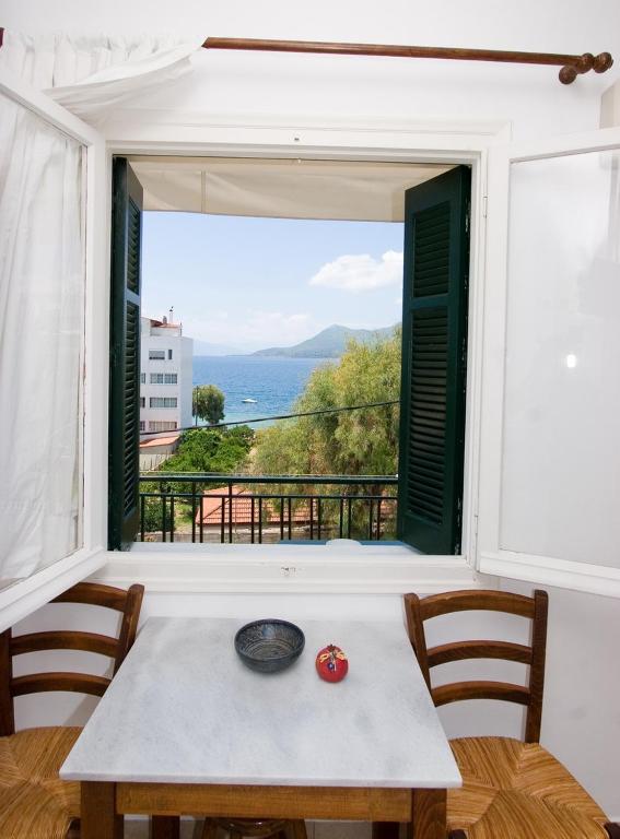 a table with a view of the ocean from a window at Soile Georgia in Loutra Edipsou
