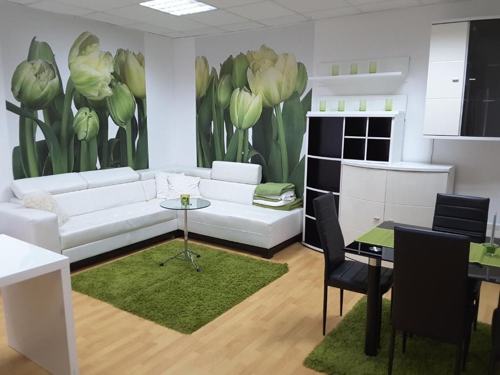 a living room with a white couch and flowers on the wall at DELUX duplex apartment in Maribor