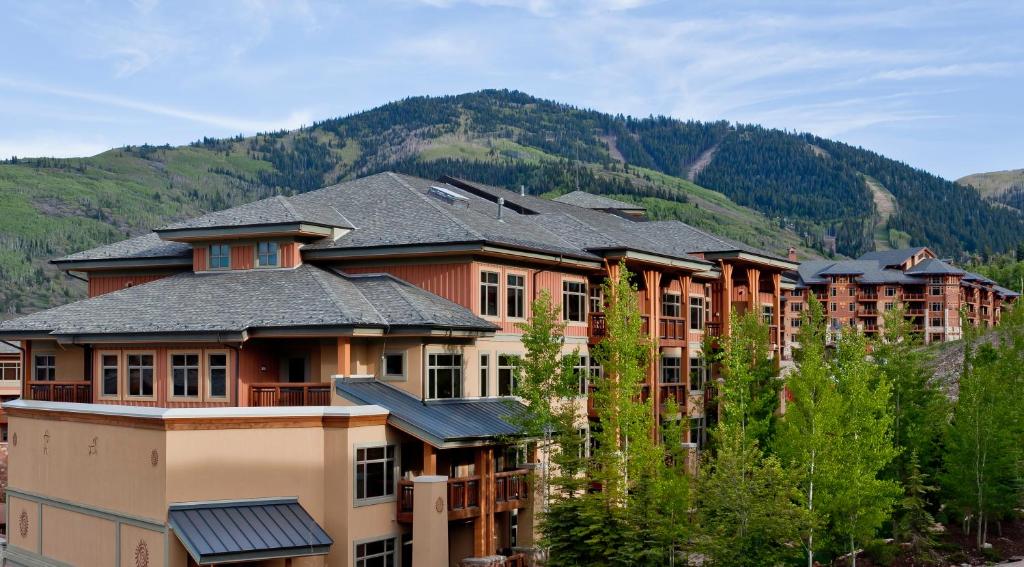 um grande edifício de apartamentos com uma montanha ao fundo em Sundial Lodge by All Seasons Resort Lodging em Park City