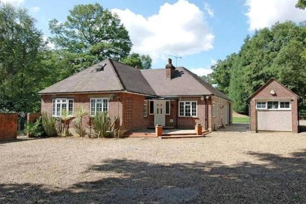 une maison en briques avec un garage et une allée dans l'établissement The Caduceus- Residence, à Chertsey