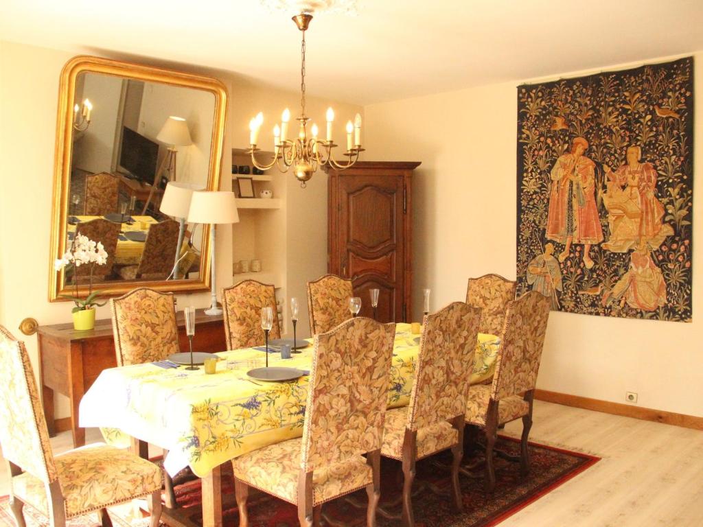 a dining room with a table and a painting on the wall at Beautiful country house with enclosed garden in green surroundings in Burgundy in Bouix