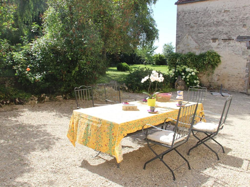 a table with a yellow table cloth and two chairs at Beautiful country house with enclosed garden in green surroundings in Burgundy in Bouix
