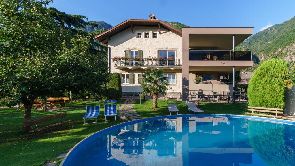 une villa avec une piscine en face d'une maison dans l'établissement Pension Sunnhofer, à Vilpiano