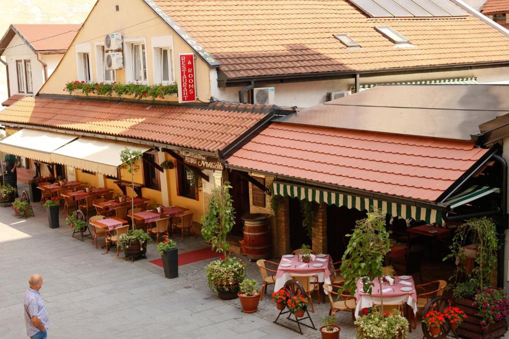 einen Blick über ein Restaurant mit Tischen und Stühlen in der Unterkunft Rooms Konak Mikan in Belgrad