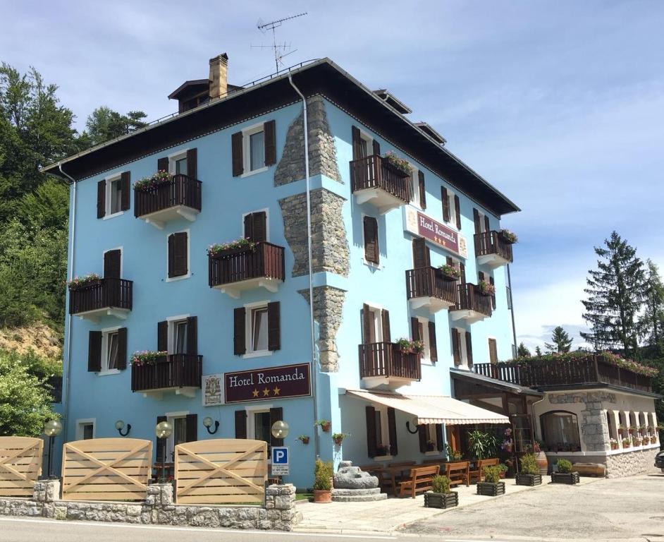um edifício azul com varandas ao lado em Hotel Romanda em Lavarone