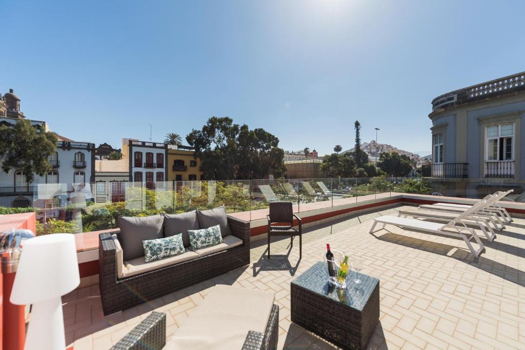 a patio with couches and chairs on a roof at Cathedral Suites in Las Palmas de Gran Canaria