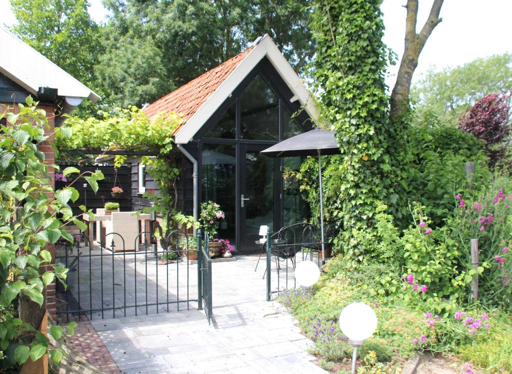 a garden entrance to a house with a black gate at Hoeve Altena Guesthouse in Woudrichem