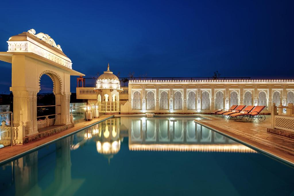 un edificio con piscina frente a un edificio en Hotel Rajasthan Palace en Jaipur