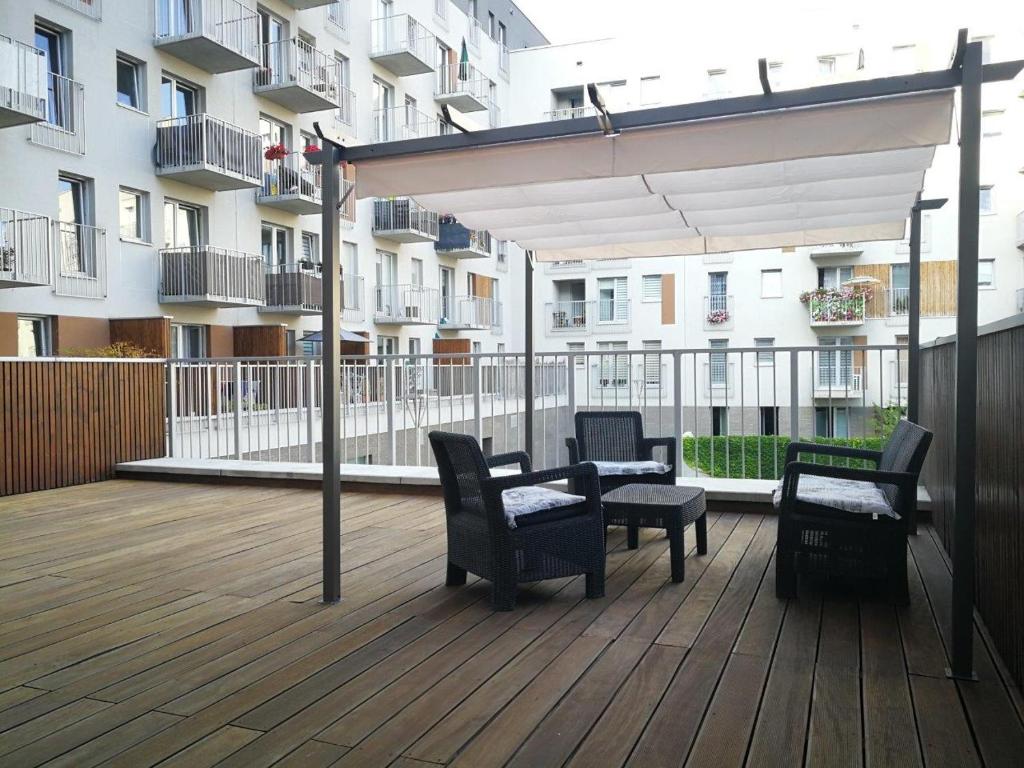 a patio with chairs and a table on a deck at Apartament nad Odrą z tarasem in Wrocław