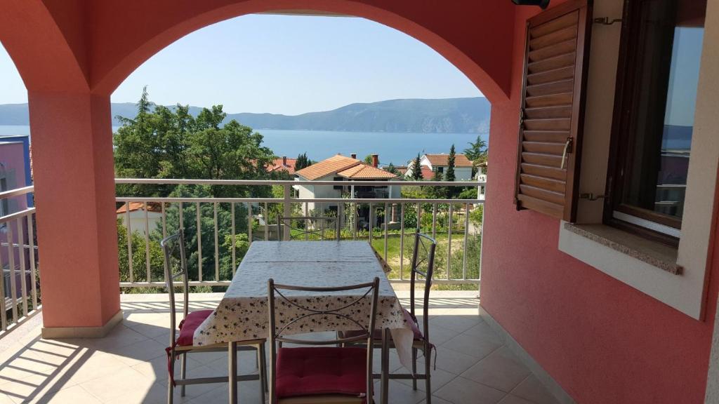 a table and chairs on a balcony with a view of the water at apartmani Vesna in Pinezici