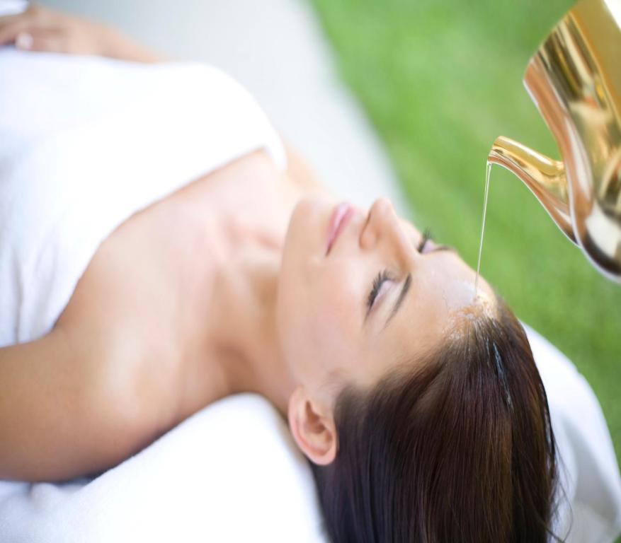 a woman laying on a bed with a hair drier at Hotel Neptun - Terme & Wellness Lifeclass in Portorož