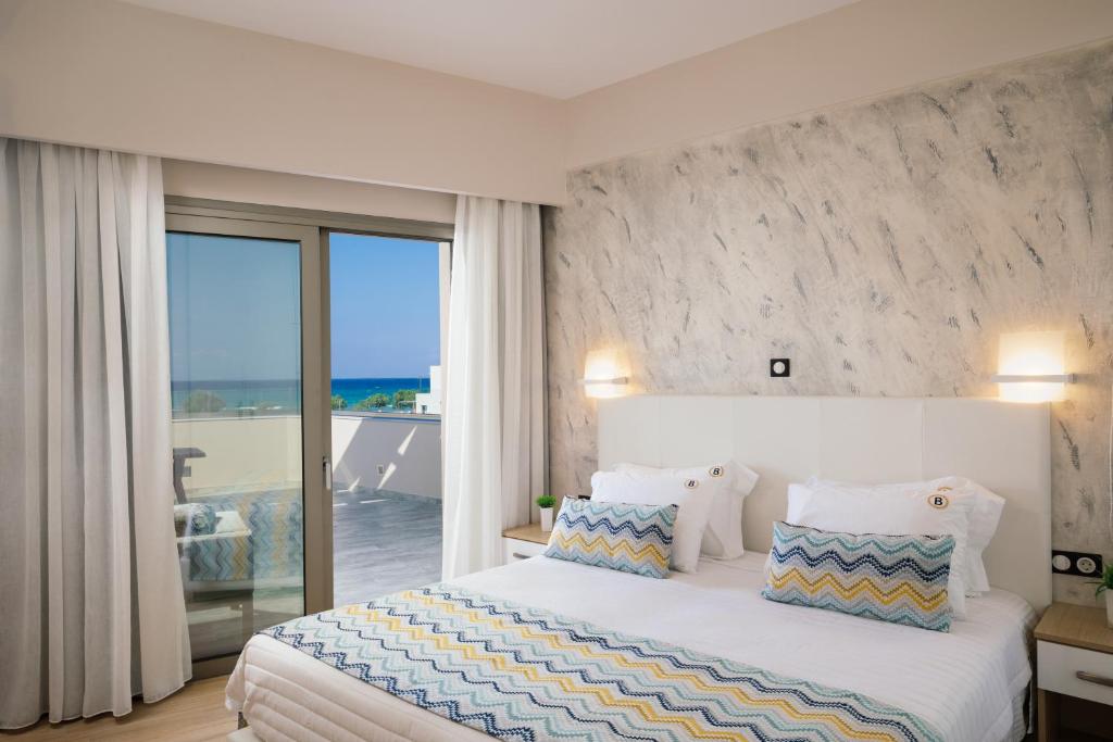a bedroom with a large bed with a view of the ocean at Belvedere Luxury Apartments & Spa in Plakias