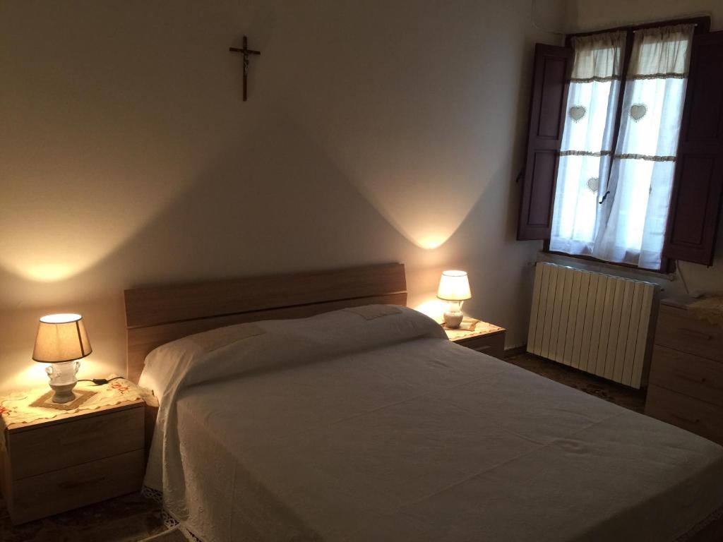 1 dormitorio con 1 cama blanca y 2 lámparas en las mesas en Casa Mia, en Taurisano