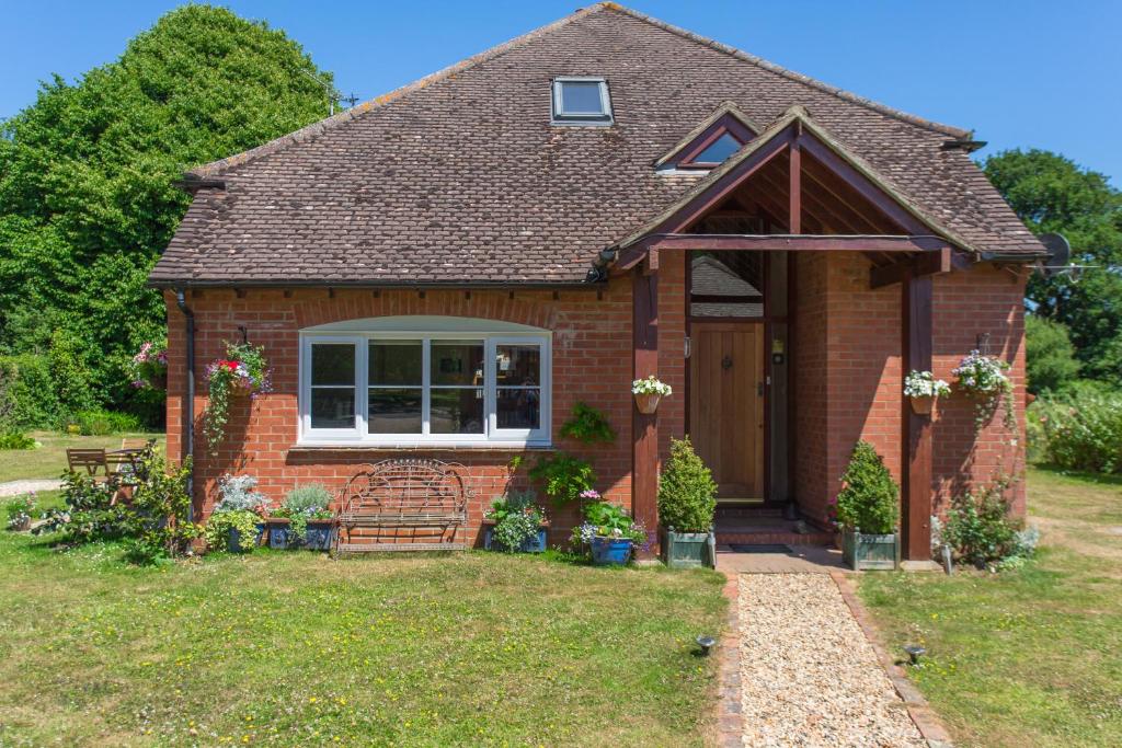 a small red brick house with a porch at Linden House in West Wittering