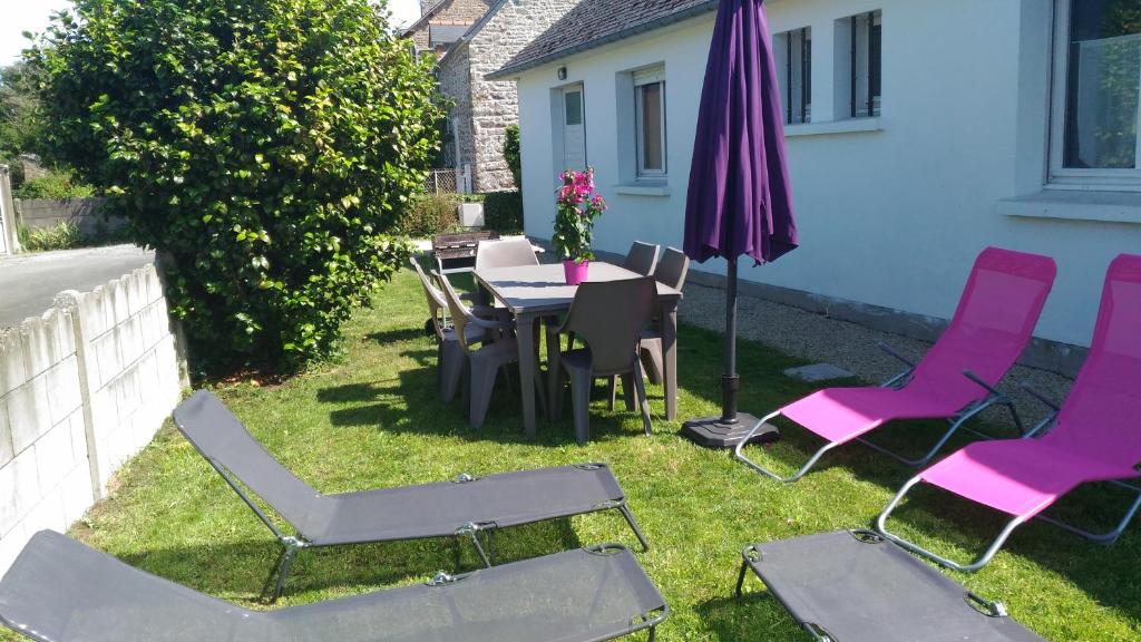 patio con tavolo, sedie e ombrellone di Maison proche Mont St Michel et St Malo a Roz-sur-Couesnon