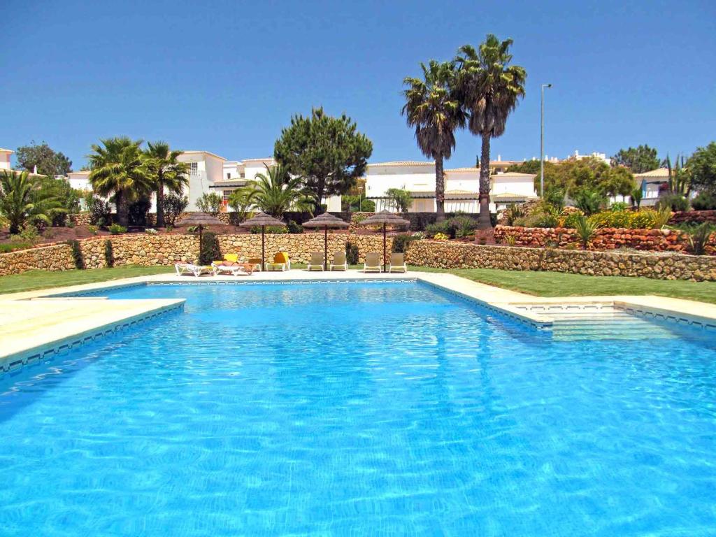 a large blue swimming pool with palm trees in the background at Casa Blue Horizon in Carvoeiro