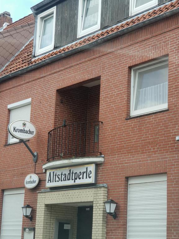 un edificio in mattoni con un cartello per aitzdatabase di Altstadtperle a Emden