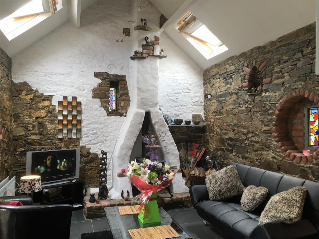 uma sala de estar com uma parede de pedra em The Barn at Pink Cottage em Crossgar