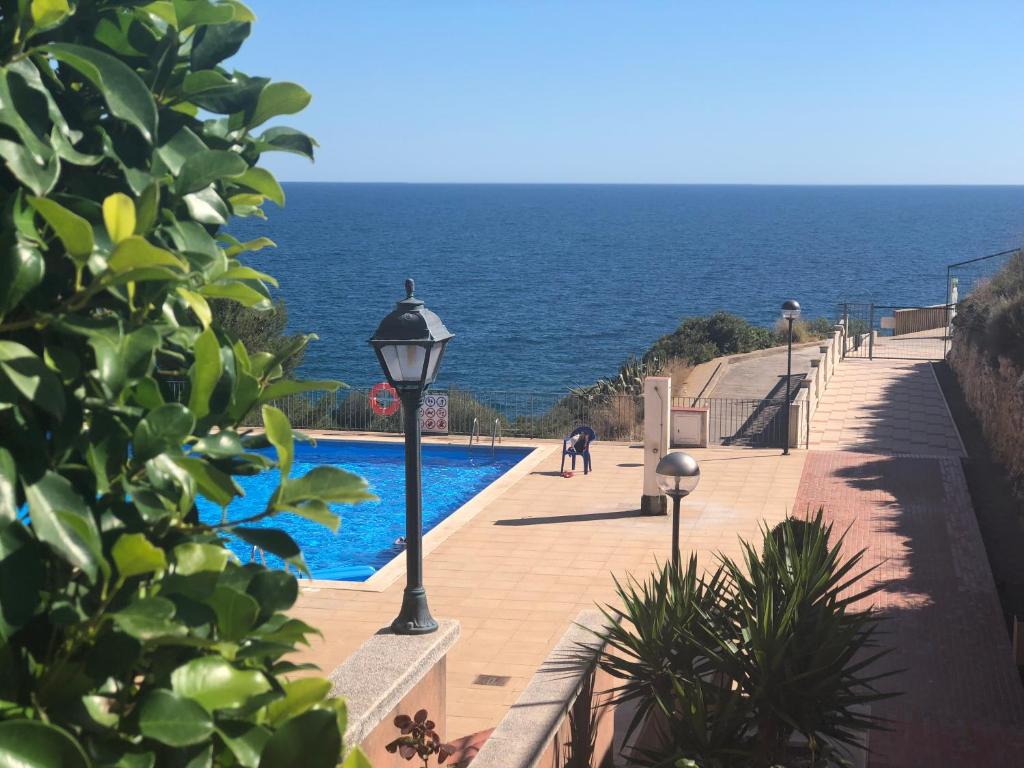 a swimming pool with the ocean in the background at SunAndBed ATICO FARO in Salou
