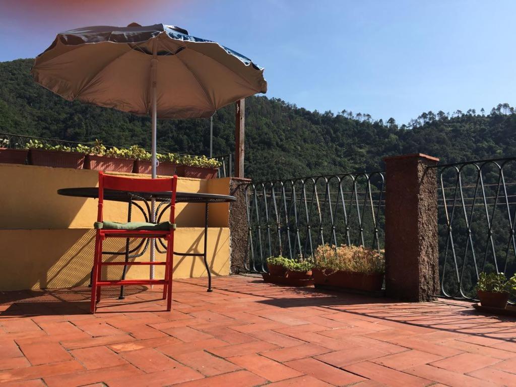 a red chair and an umbrella on a patio at Cinqueterre - Terrace and beautiful view in Levanto