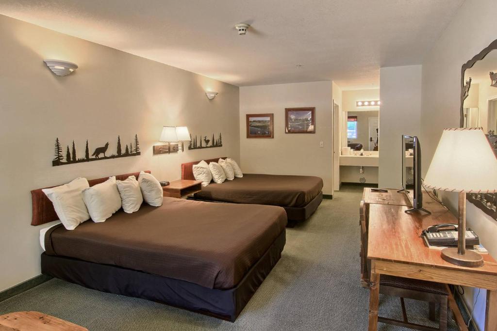 BellaireにあるThe Legend Cottage Innのベッド2台とデスクが備わるホテルルームです。
