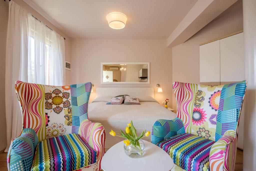 sypialnia z łóżkiem, 2 krzesłami i stołem w obiekcie Apartments Javor w Rovinj