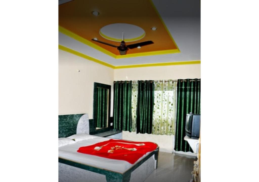 een slaapkamer met een bed met een rode deken bij Hotel Arihant in Pachmarhī