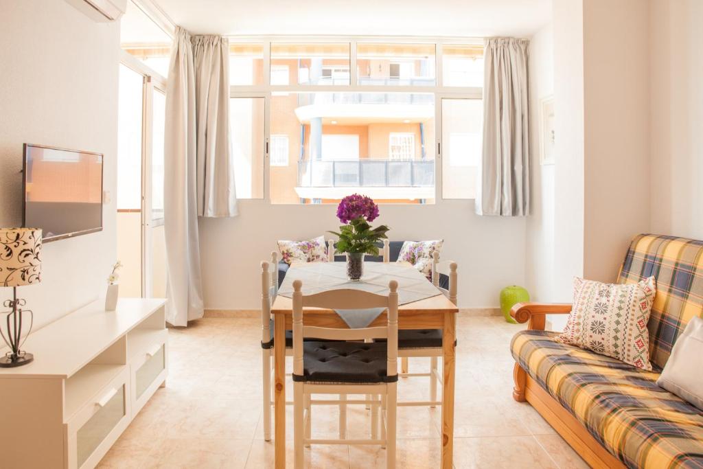 Aurinko 4 Luminoso apartamento en Fuengirola في فوينخيرولا: غرفة معيشة مع طاولة وأريكة