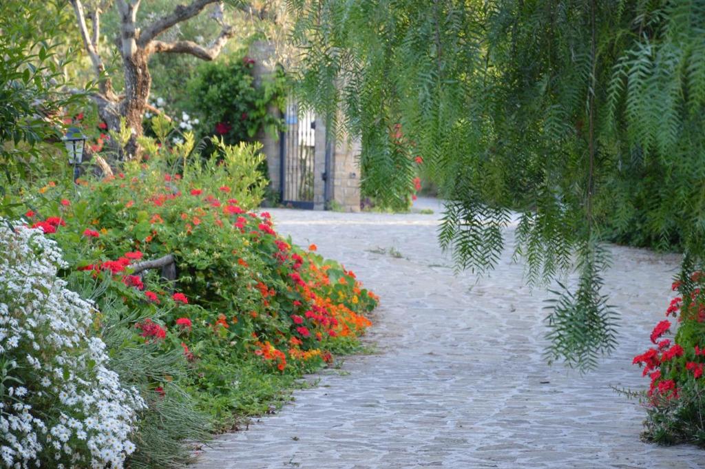 um jardim com flores vermelhas e brancas e um passadiço em Dormire al Casale em San Mauro Cilento