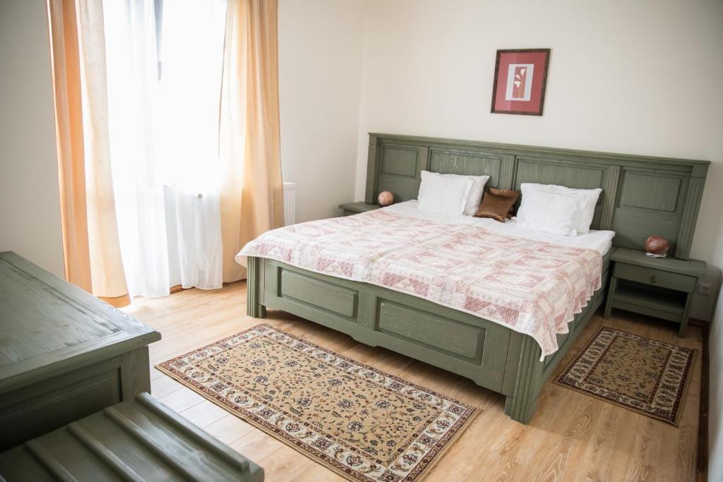 a bedroom with a green bed with two pillows at Pensiunea Panoramic in Vartop