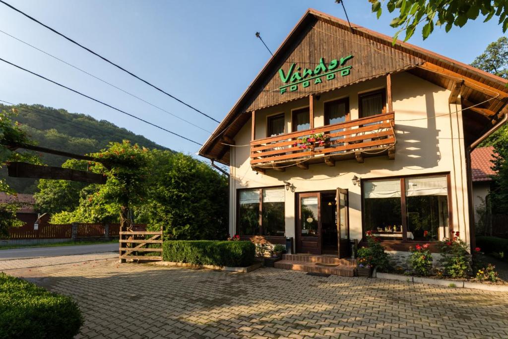 a building with a sign on the front of it at Pensiunea Restaurant Vándor in Cîmpu Cetăţii