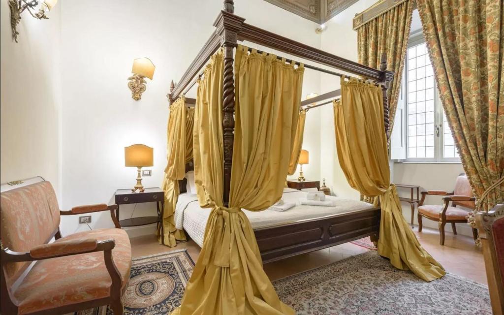 a bedroom with a canopy bed with yellow curtains at Residenza Sinibaldi in Rome