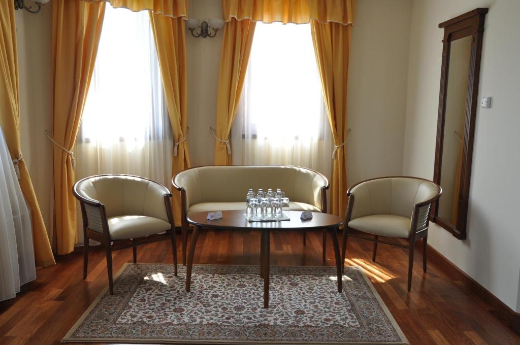 sala de estar con 2 sillas y mesa en Nimród Bioszálloda és Bioétterem, en Karcag