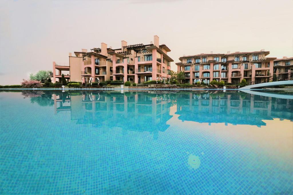 uma grande piscina de água com edifícios ao fundo em Kaliakria Sea View Apartments em Topola