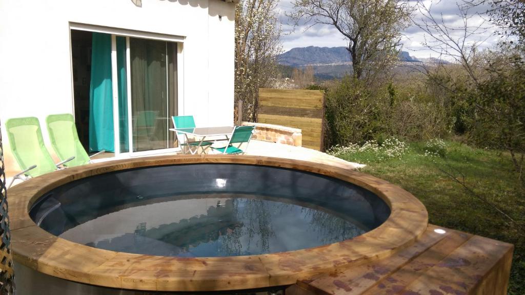 una piscina circular en un patio trasero con sillas y mesa en Spa Cabanon de Charme - Le Garagaï, en Meyreuil