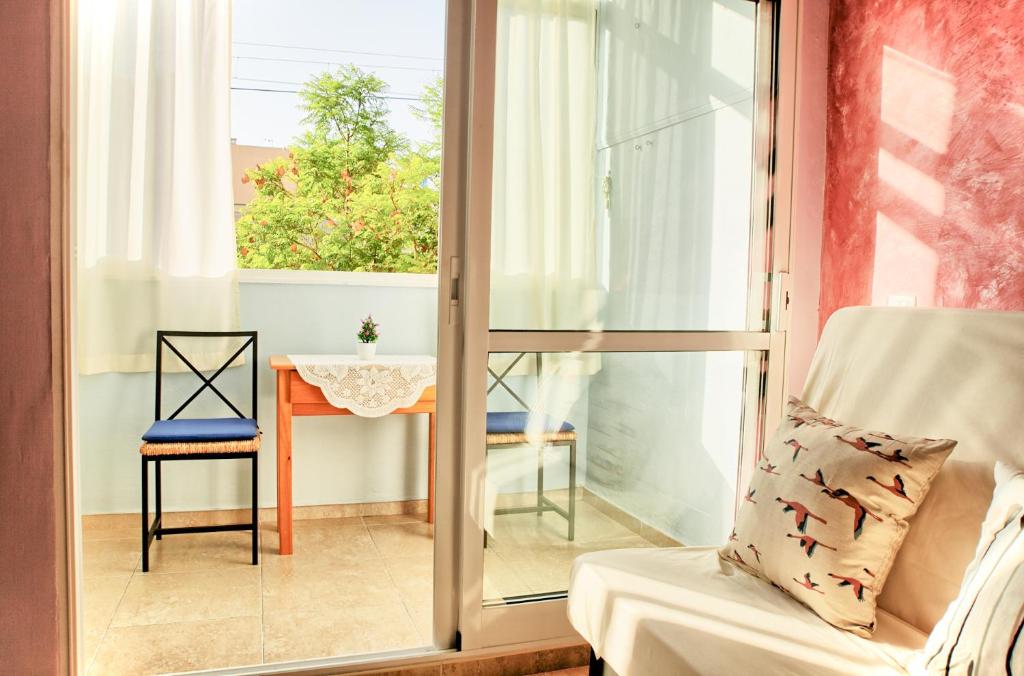 フエンヒロラにあるAurinko 6 Acogedor apartamento en Fuengirolaの窓、テーブル、椅子が備わる客室です。