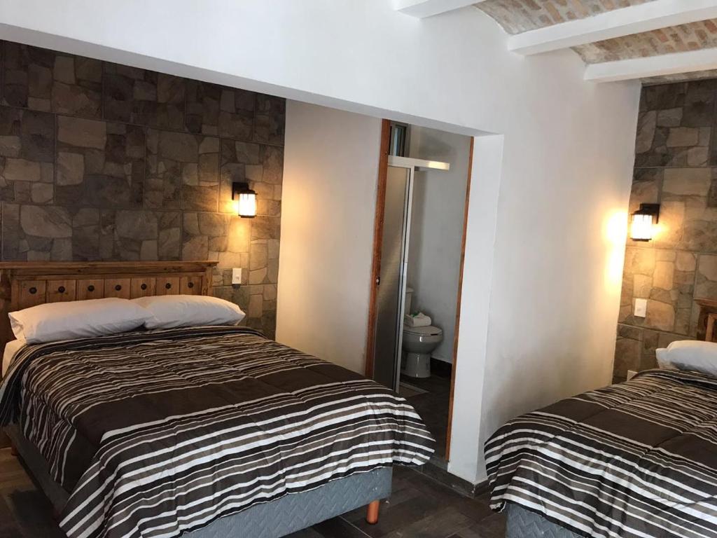 Una habitación de hotel con dos camas y un baño. en Venados Inn, en Mazatlán