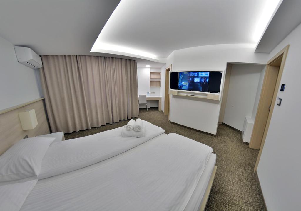 a hotel room with two beds and a flat screen tv at Apartment OneClickRent_05 - Smart House in Chişinău