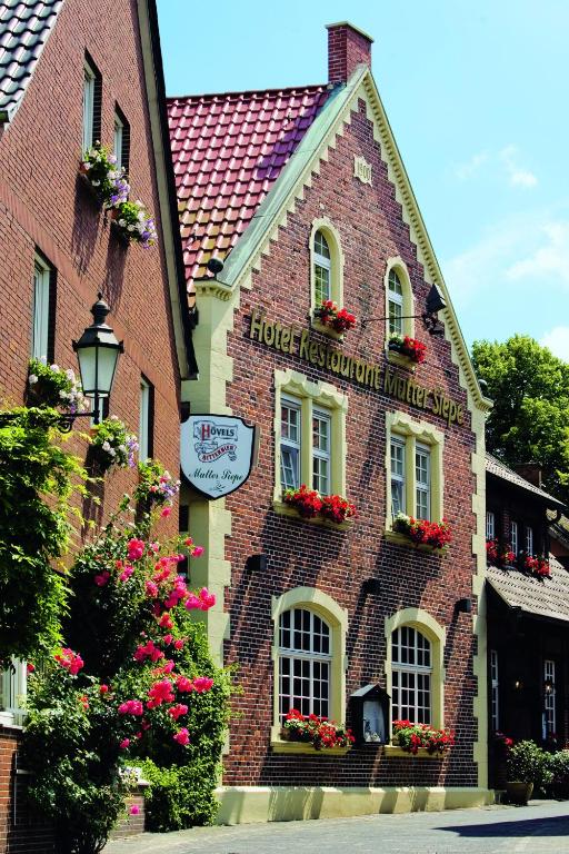 un edificio in mattoni con fiori alle finestre di Mutter Siepe a Lüdinghausen
