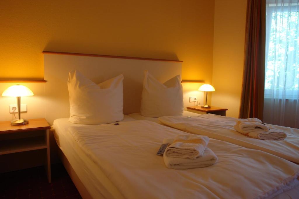 a hotel room with a bed with towels on it at Pension Zeitlos in Potsdam
