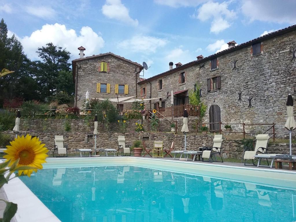 a house with a swimming pool in front of a building at B&B Monte Splendore in Pietralunga