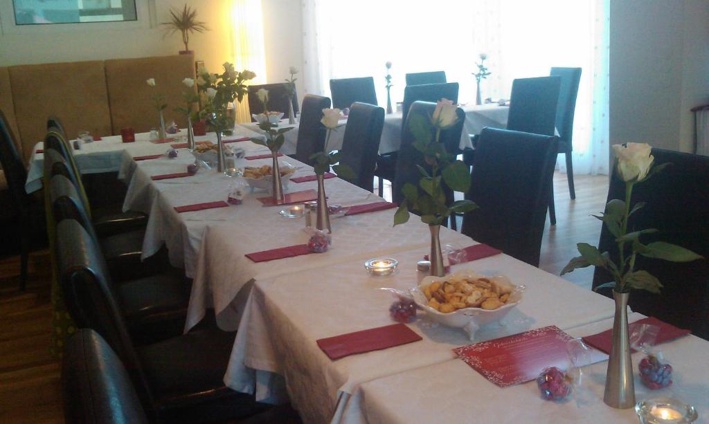 a group of long tables with flowers on them at Pension Zeitlos in Potsdam
