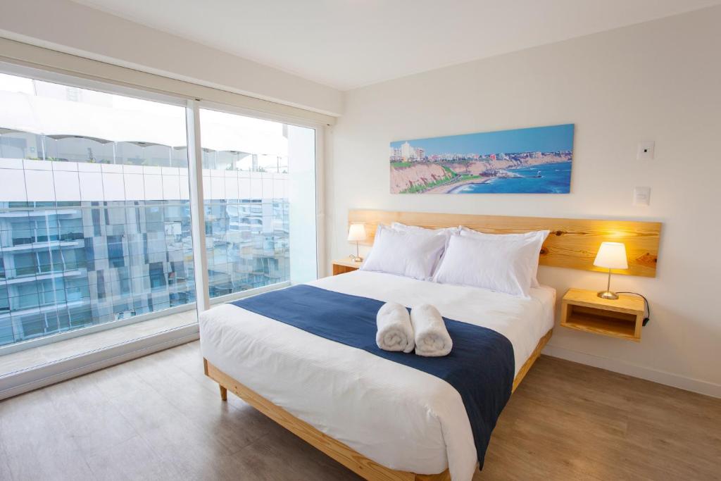 a bedroom with a large bed and a large window at Lima Walking Apartments - Central Miraflores in Lima