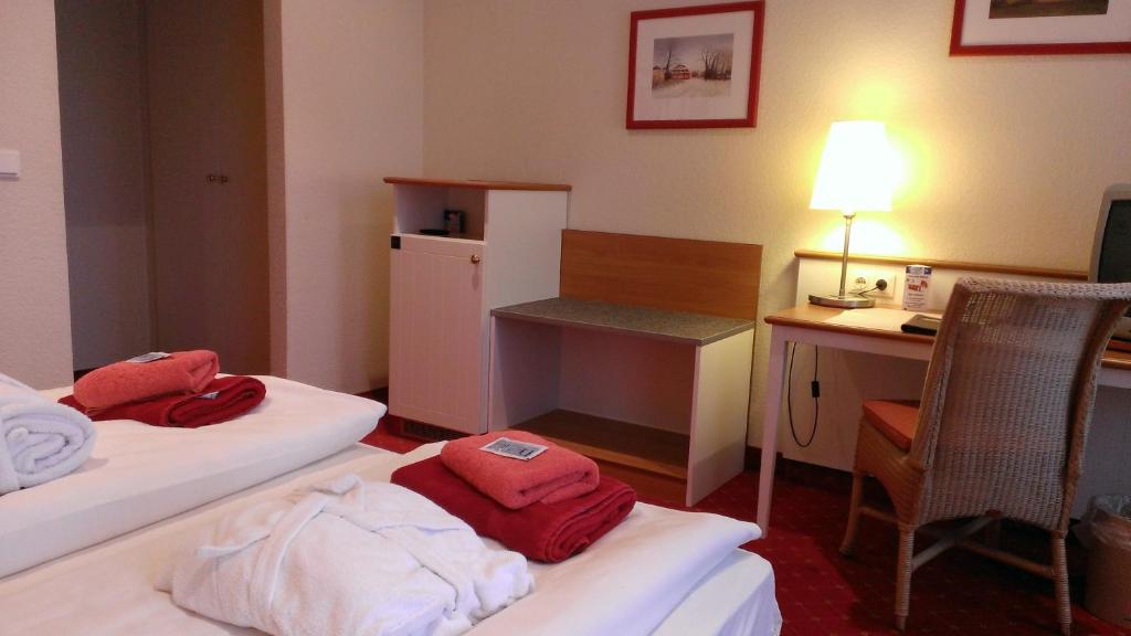 a hotel room with two beds and a desk at Pension Zeitlos in Potsdam