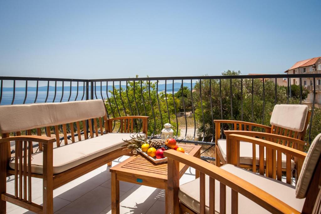 - un balcon avec un canapé et une corbeille de fruits sur une table dans l'établissement Apartments Sarbunal, à Bol