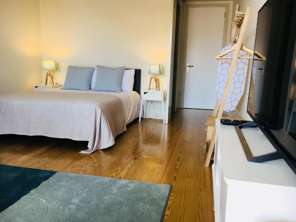 ポルトにあるVitoria Studio Residence - Downtownのベッドルーム(青い枕とテレビ付)