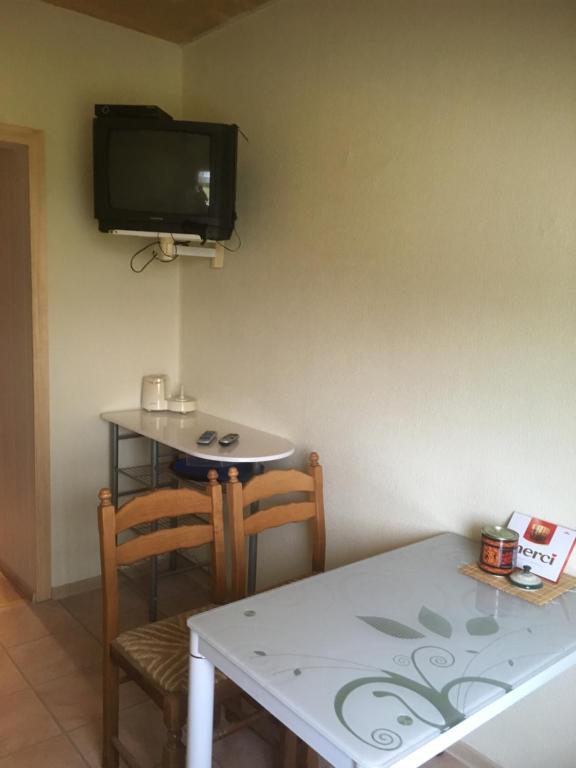 uma sala de jantar com uma mesa e uma televisão na parede em Mustvee Kortermajutus em Mustvee