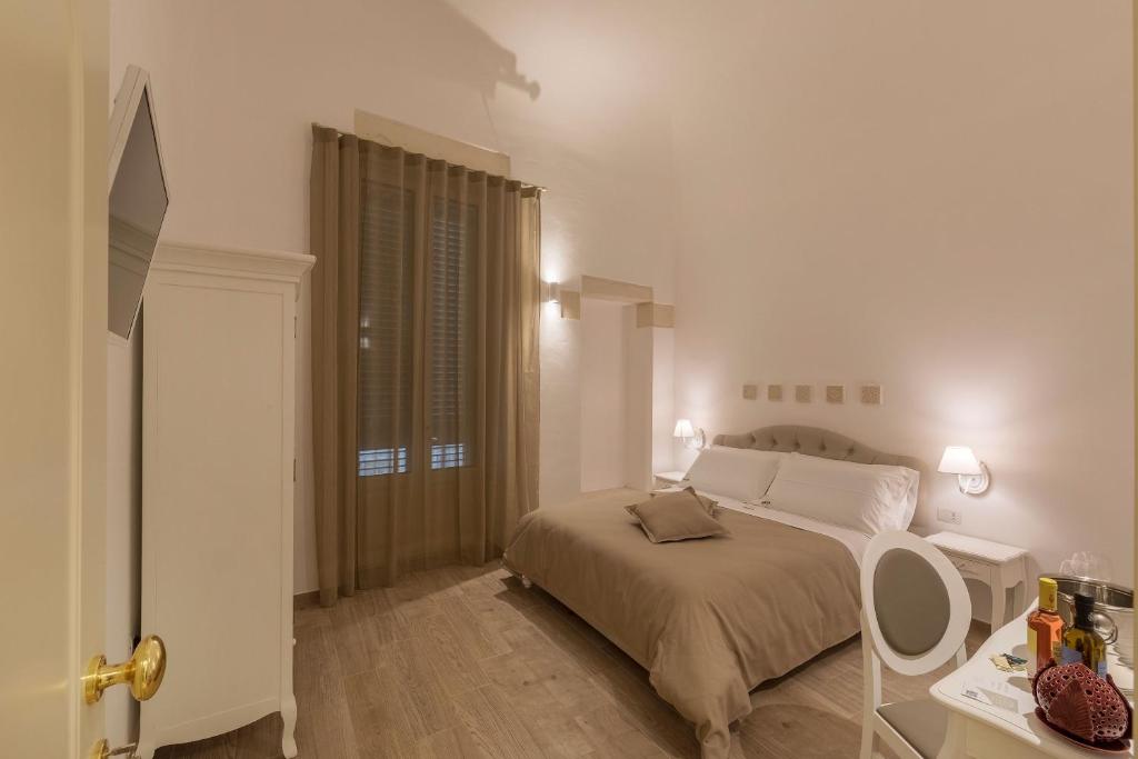 1 dormitorio con cama y mesa con espejo en Agape Rooms en Lecce