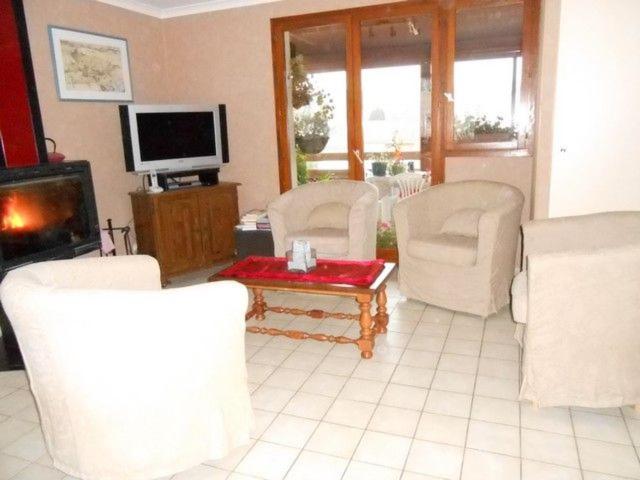 a living room with white chairs and a tv at Villa Agapenthe in Cluny