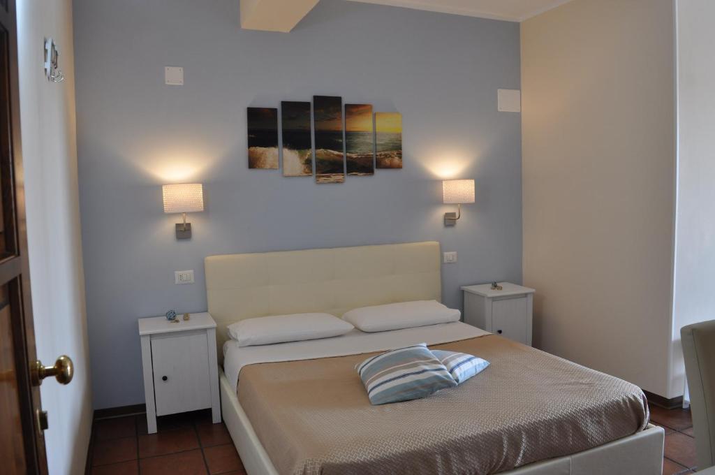 特羅佩阿的住宿－Il Palombaro Rooms，一间卧室配有一张带两张桌子和两盏灯的床。